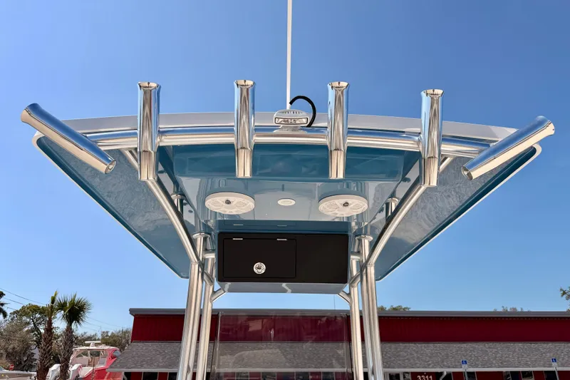 Slide: The Image of Bay Rider 2460 FS Skiff 2026 T-top with rod holders against clear blue sky. - 42