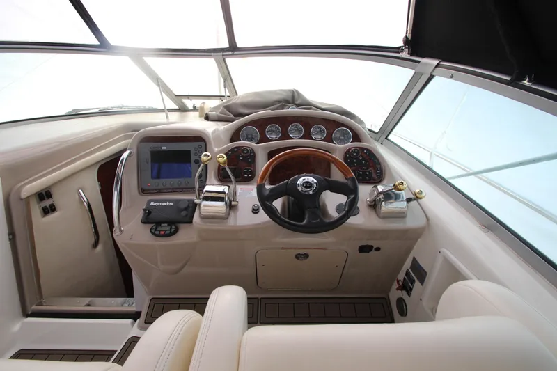 Slide: The Image of 2005 Sea Ray 340 Sundancer helm with steering wheel and navigation controls. - 23