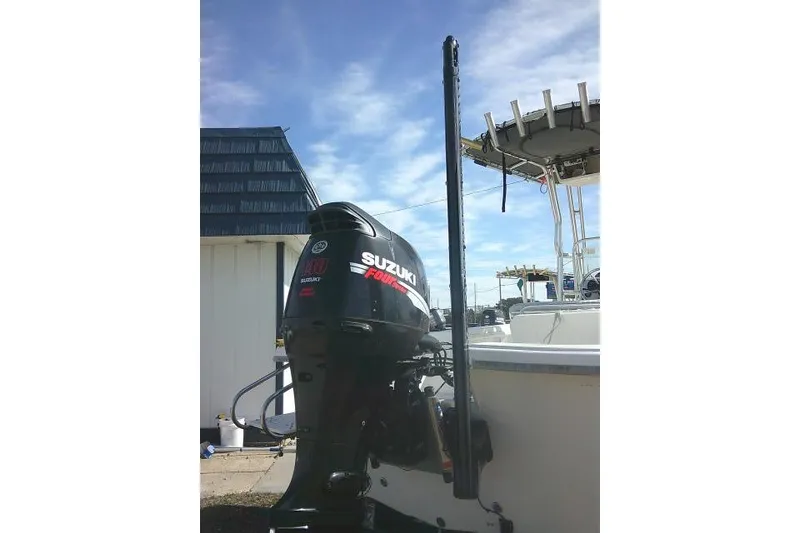 Slide: The Image of 2008 Carolina Skiff 218 DLV Elite with Suzuki outboard motor, docked under clear sky. - 11