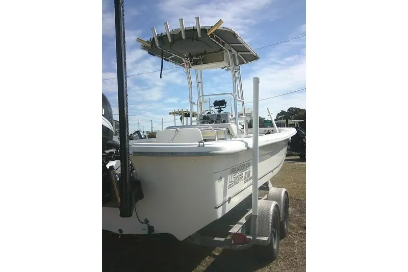 Slide: The Image of 2008 Carolina Skiff 218 DLV Elite boat on trailer, featuring T-top and dual axles. - 12