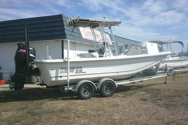 Slide: The Image of 2008 Carolina Skiff 218 DLV Elite boat on trailer, parked outdoors near building. - 13