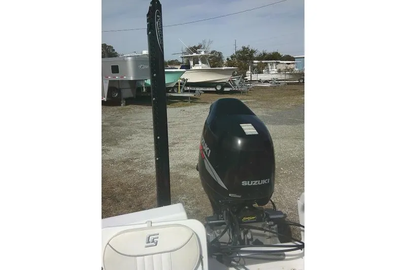 Slide: The Image of 2008 Carolina Skiff 218 DLV Elite with Suzuki outboard motor in a boatyard. - 24