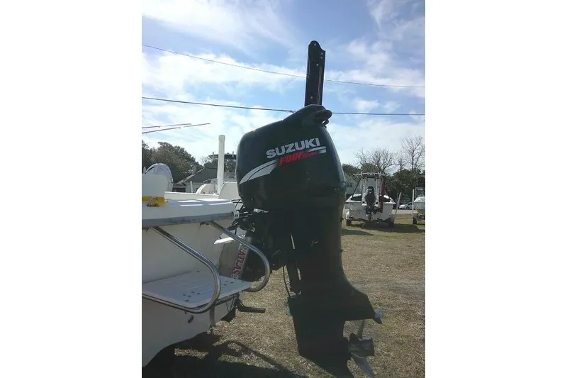 Slide: The Image of 2008 Carolina Skiff 218 DLV Elite with Suzuki outboard motor in a sunny outdoor setting. - 9