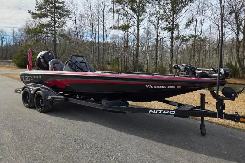 Slide: The Image of 2022 Nitro Z21 XL boat on trailer, parked on a road with trees in the background. - 1