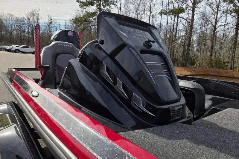 Slide: The Image of 2022 Nitro Z21 XL boat with sleek black and red design, parked outdoors. - 14