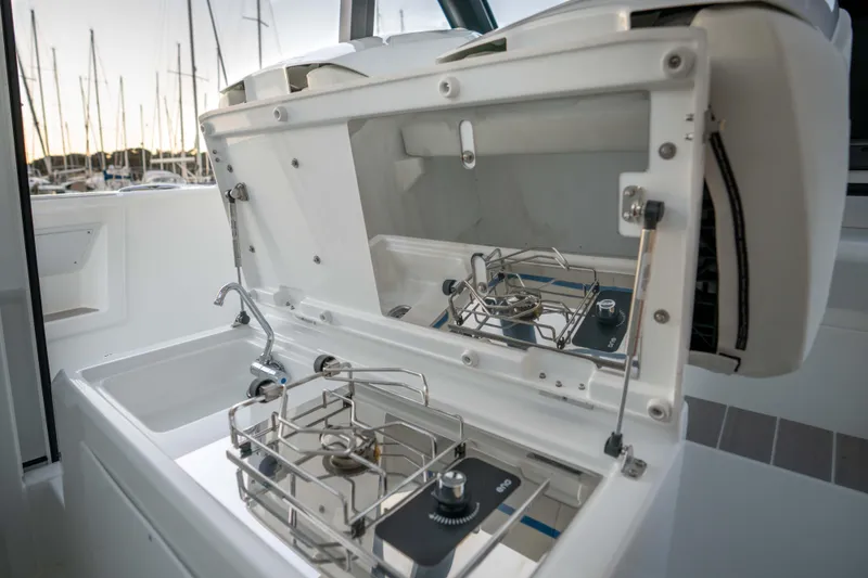 Slide: The Image of 2026 Wellcraft 28 Explorer boat kitchen with stove and sink, docked at marina. - 11