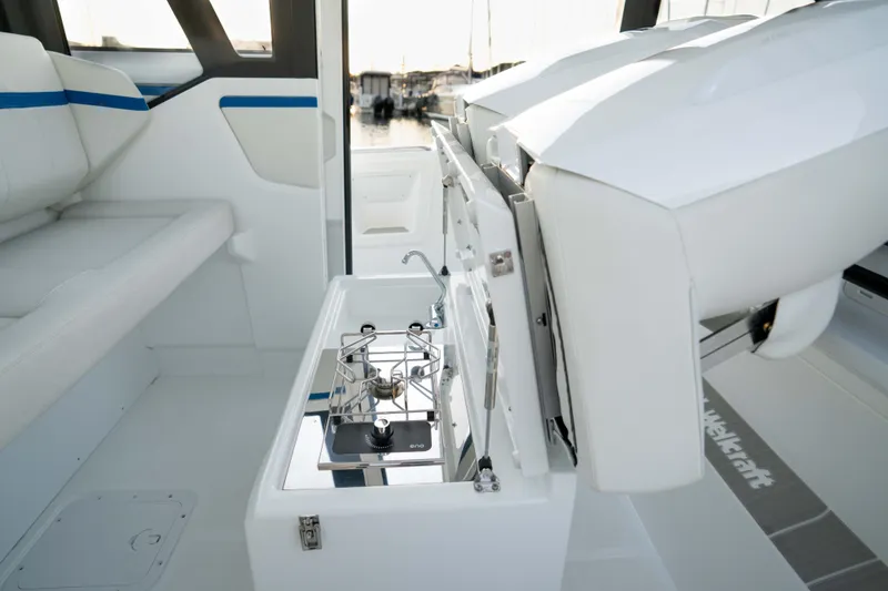 Slide: The Image of Interior of 2026 Wellcraft 28 Explorer boat with compact kitchen setup. - 12