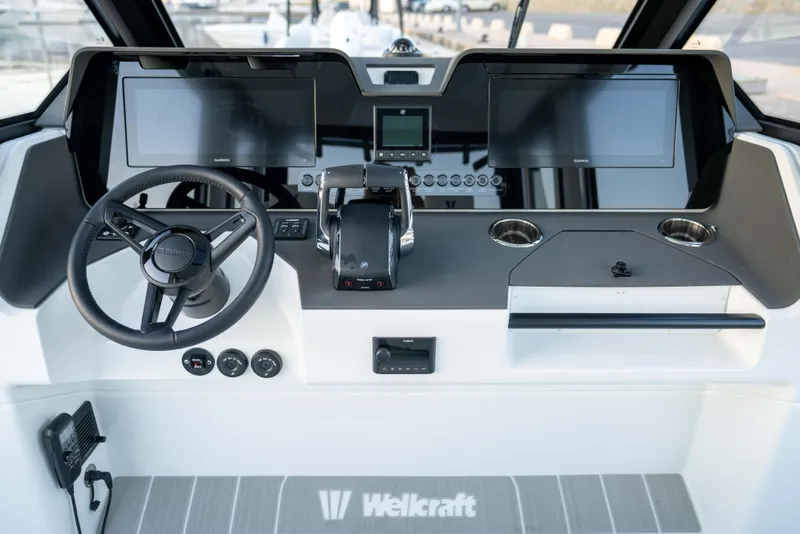 Slide: The Image of Helm of 2026 Wellcraft 28 Explorer boat with modern controls and dual screens. - 13