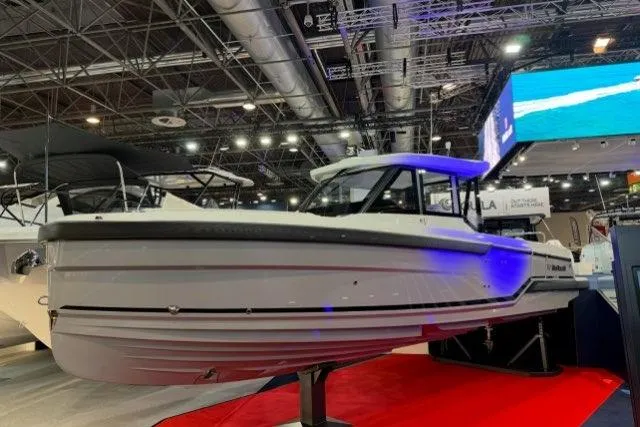 Slide: The Image of 2026 Wellcraft 28 Explorer boat displayed at an indoor exhibition, featuring sleek design and modern lighting. - 2