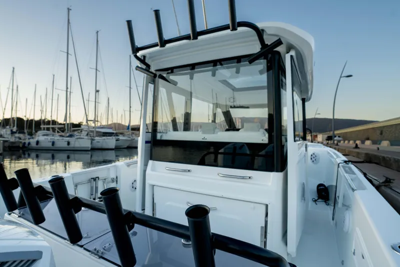 Slide: The Image of 2026 Wellcraft 28 Explorer boat docked in marina, surrounded by sailboats. - 20