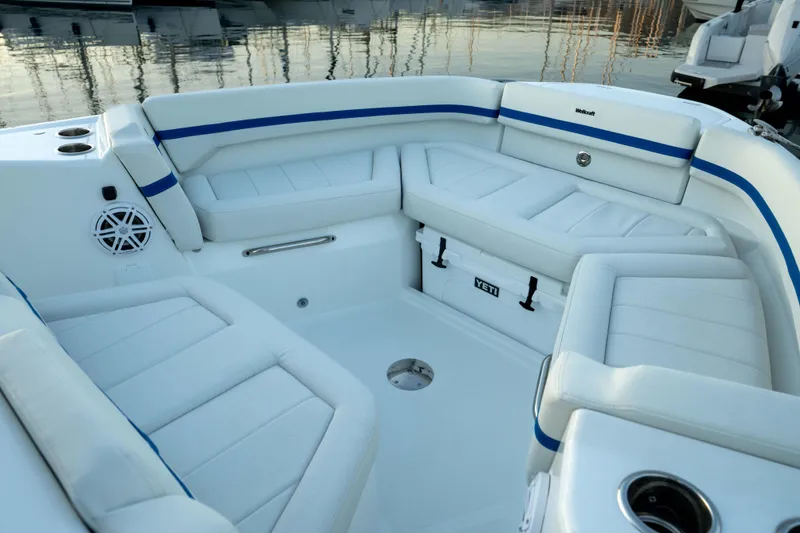 Slide: The Image of Luxurious seating area on 2026 Wellcraft 28 Explorer boat with white cushions and blue accents. - 22