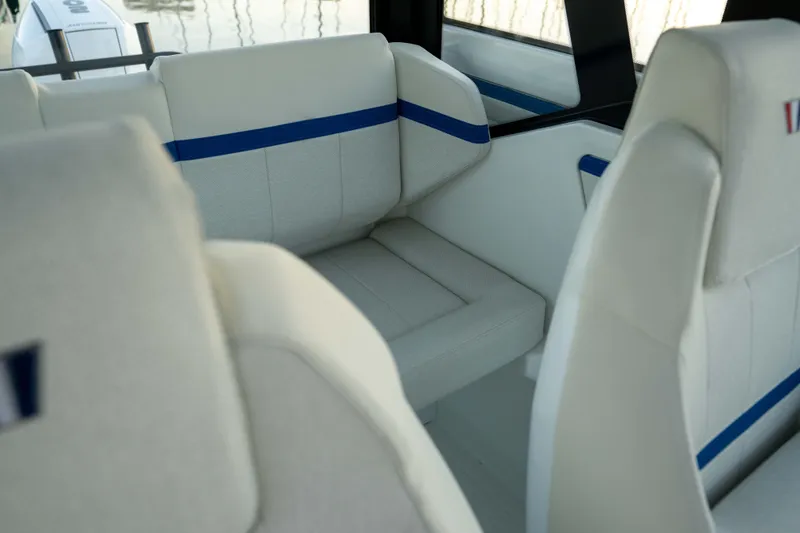 Slide: The Image of Interior seating of 2026 Wellcraft 28 Explorer boat, featuring white and blue upholstery. - 9