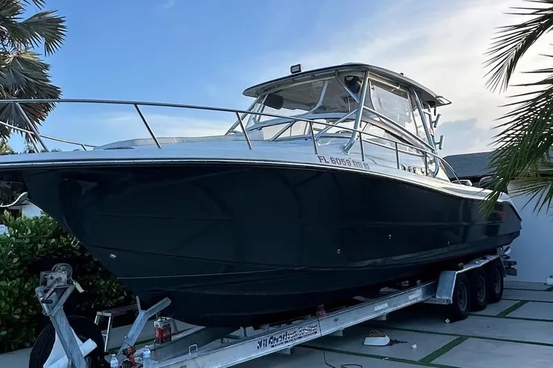 The Image of 2010 Triton 351 Express boat docked in a marina, surrounded by calm water. - 0