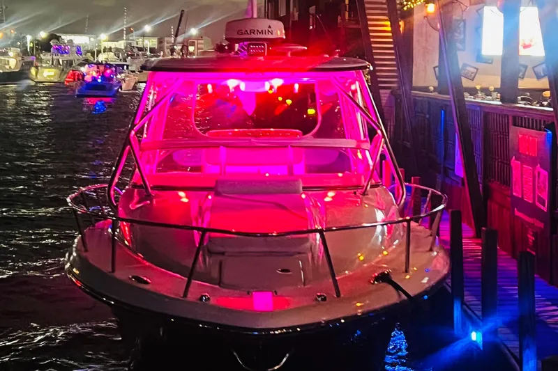 Slide: The Image of 2010 Triton 351 Express boat interior with helm station and seating, docked at marina. - 12