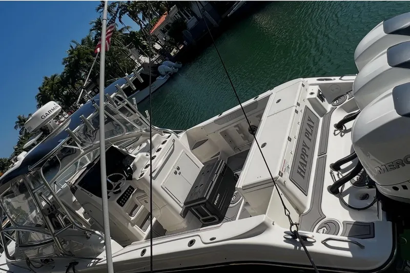 Slide: The Image of 2010 Triton 351 Express boat interior with seating and controls, docked by the water. - 13