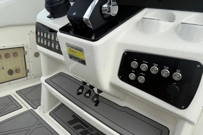 Slide: The Image of Control panel of a 2010 Triton 351 Express boat with labeled switches and capacity sign. - 18