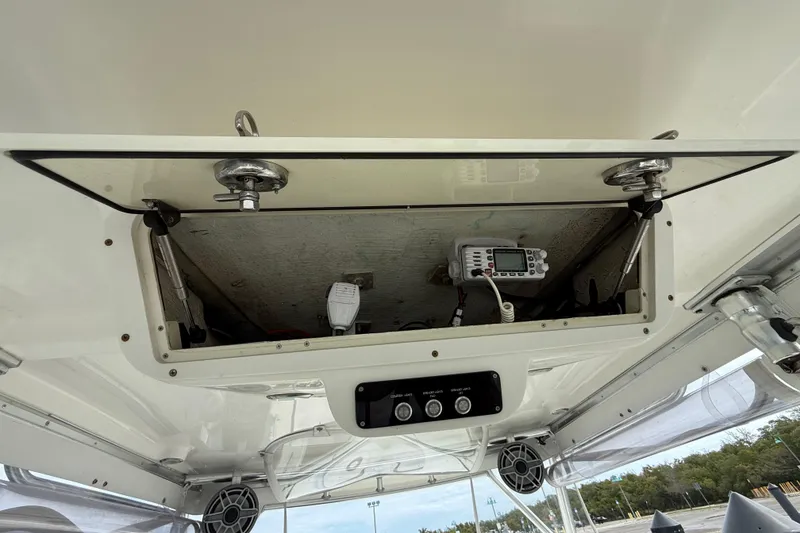 Slide: The Image of Open storage compartment on 2010 Triton 351 Express boat with electronic equipment inside. - 20