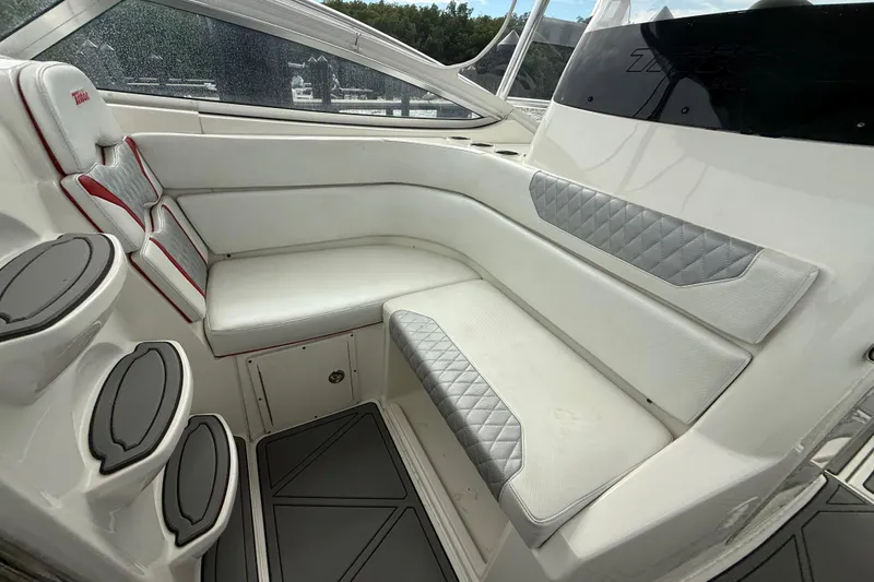 Slide: The Image of 2010 Triton 351 Express boat interior with white cushioned seating and cup holders. - 23