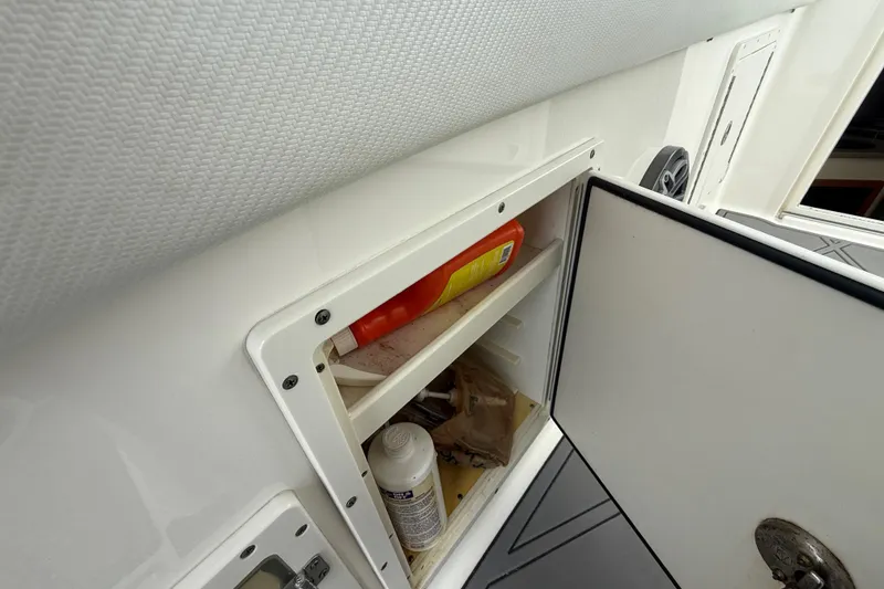 Slide: The Image of Storage compartment on a 2010 Triton 351 Express boat, containing various items. - 24