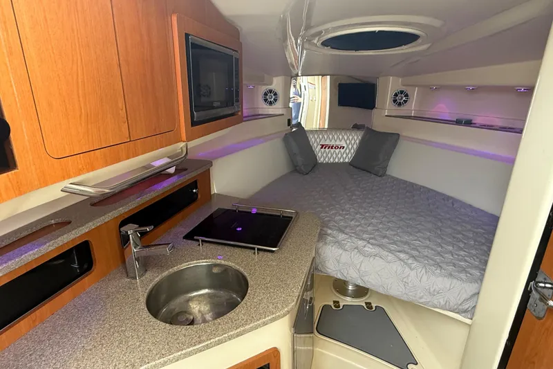 Slide: The Image of Luxurious interior of 2010 Triton 351 Express boat with kitchenette and cozy sleeping area. - 32