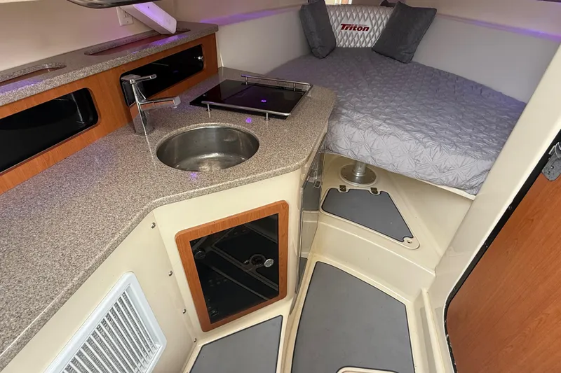 Slide: The Image of 2010 Triton 351 Express cabin interior with kitchenette and bed. - 33