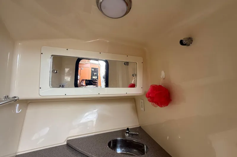 Slide: The Image of Interior of 2010 Triton 351 Express boat bathroom with sink and mirror. - 42