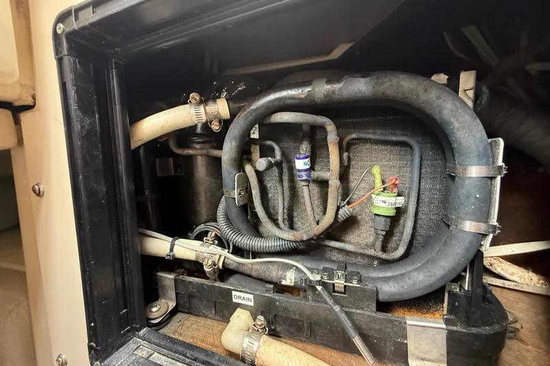 Slide: The Image of Engine compartment of a 2010 Triton 351 Express boat, showing hoses and components. - 44