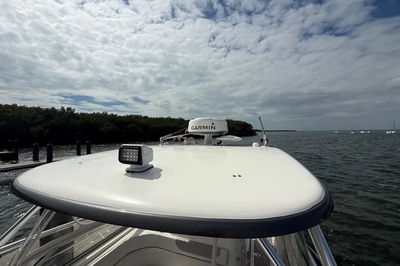 Slide: The Image of 2010 Triton 351 Express boat with Garmin radar on calm waters under cloudy sky. - 49