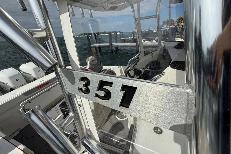 Slide: The Image of 2010 Triton 351 Express boat with sleek metallic design and powerful engines. - 50