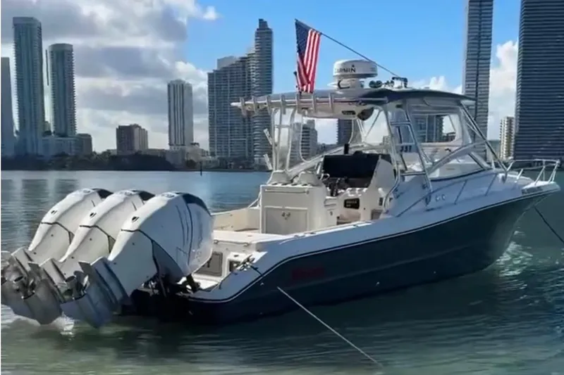 Slide: The Image of 2010 Triton 351 Express boat with triple engines, docked near city skyline. - 51