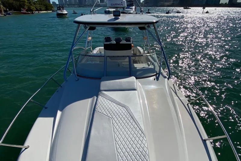 Slide: The Image of 2010 Triton 351 Express boat interior at dock, open storage compartments, ocean view. - 7