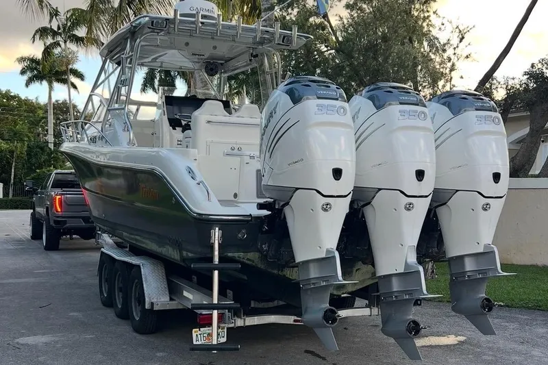 Slide: The Image of Open storage compartment on 2010 Triton 351 Express boat with Mercury engines in background. - 8