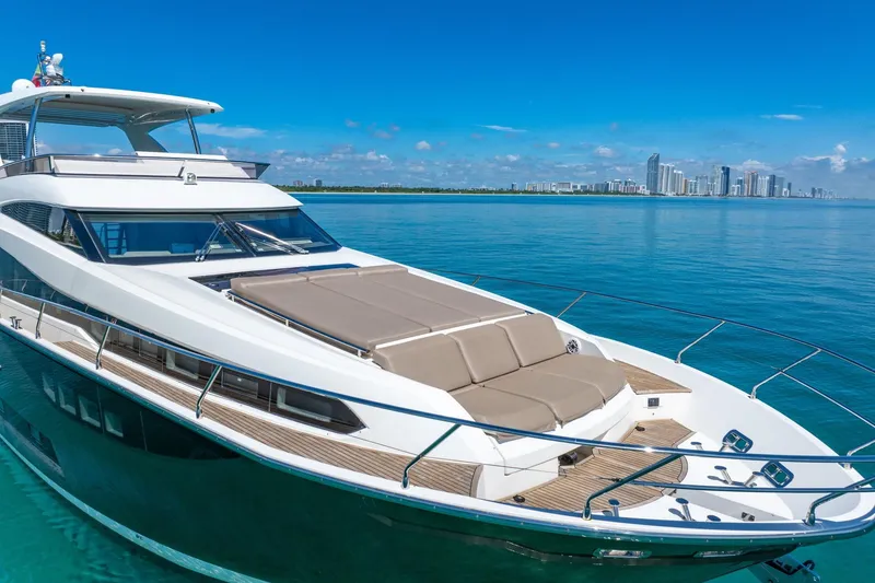 Slide: The Image of Luxurious 2015 Prestige 750 yacht cruising on clear blue waters with city skyline backdrop. - 4