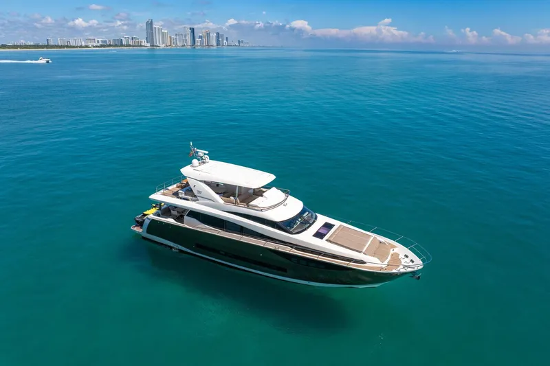 Slide: The Image of Luxurious 2015 Prestige 750 yacht cruising in clear blue waters near a city skyline. - 74