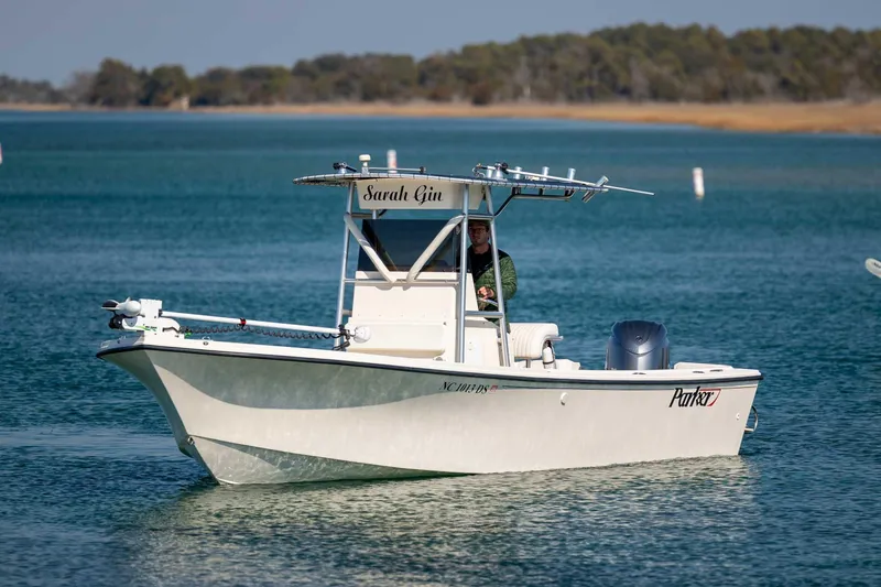 The Image of 2007 Parker 2300 Special Edition boat on calm water, featuring a center console and T-top. - 1