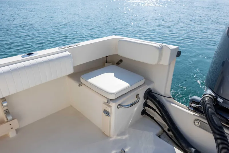 Slide: The Image of 2007 Parker 2300 Special Edition boat interior with cushioned seating by the water. - 11