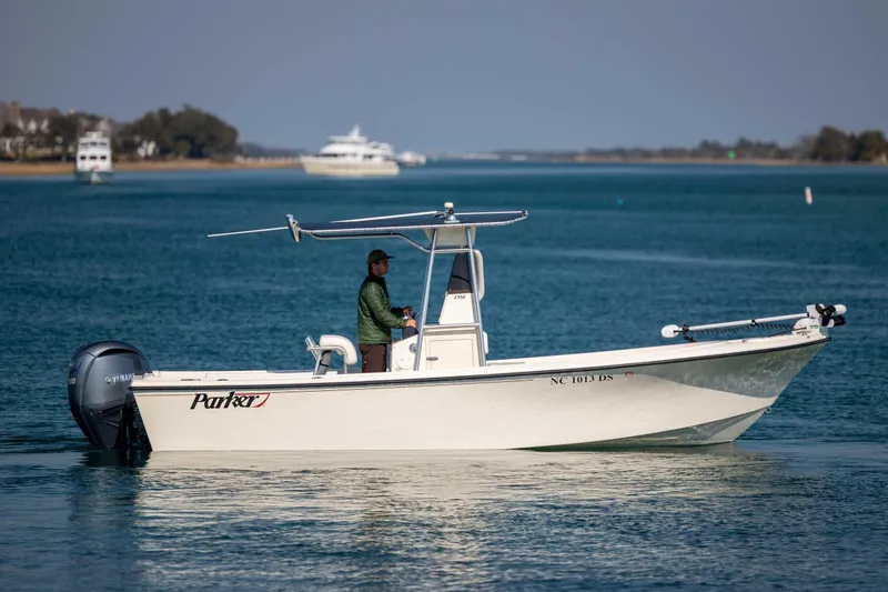 Slide: The Image of 2007 Parker 2300 Special Edition boat on calm water, with a person steering. - 3
