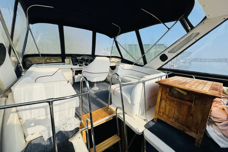 Slide: The Image of 1990 Bayliner 3888 Motoryacht interior with white seating and wooden accents. - 12