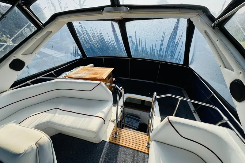 Slide: The Image of Interior of 1990 Bayliner 3888 Motoryacht with white seating and wooden accents. - 14