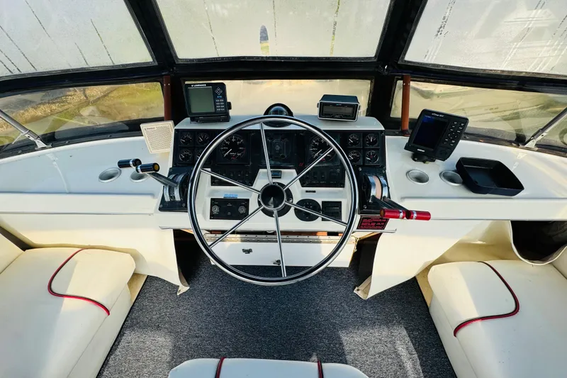 Slide: The Image of 1990 Bayliner 3888 Motoryacht helm with steering wheel, navigation instruments, and seating. - 17