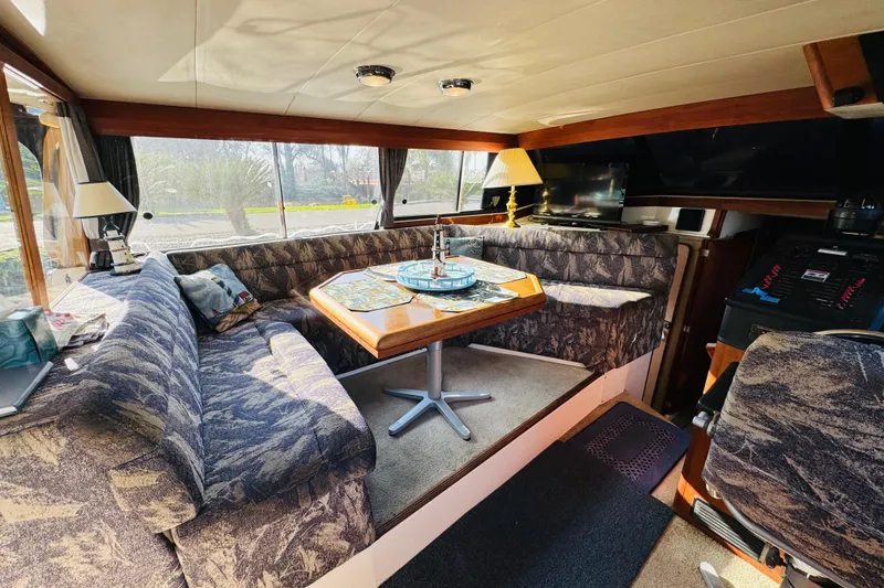 Slide: The Image of Interior of 1990 Bayliner 3888 Motoryacht with cozy seating and dining area. - 21