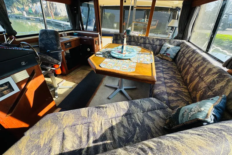 Slide: The Image of Interior of 1990 Bayliner 3888 Motoryacht with cozy seating and table setup. - 22