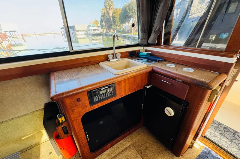 Slide: The Image of 1990 Bayliner 3888 Motoryacht interior with kitchenette, sink, and window view. - 24