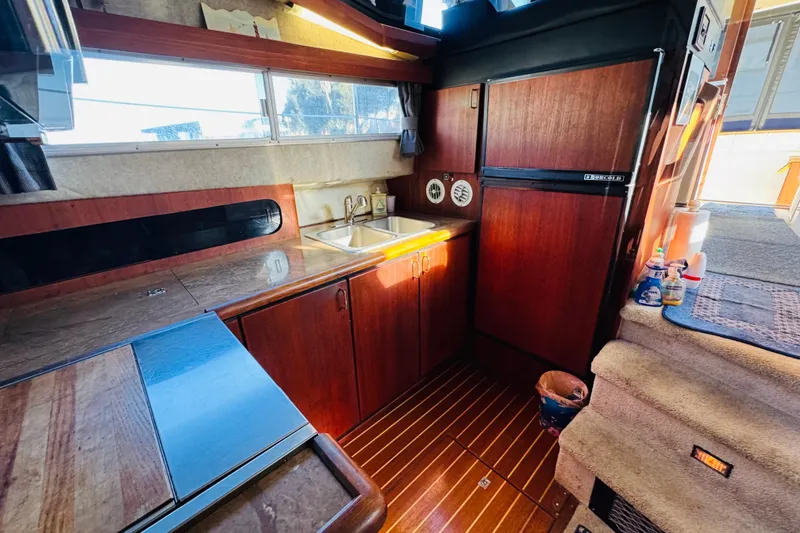 Slide: The Image of Interior of 1990 Bayliner 3888 Motoryacht kitchen with wood cabinetry and appliances. - 29
