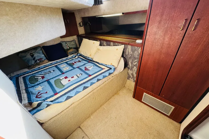 Slide: The Image of 1990 Bayliner 3888 Motoryacht cozy cabin with nautical-themed bedding and wooden cabinetry. - 31