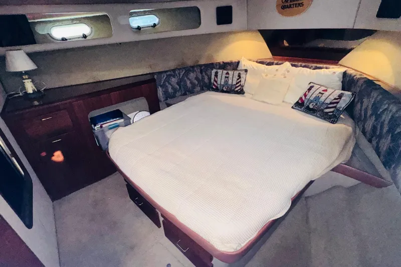 Slide: The Image of Cozy bedroom interior of 1990 Bayliner 3888 Motoryacht with bed, pillows, and wooden cabinetry. - 36