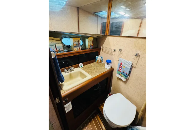 Slide: The Image of 1990 Bayliner 3888 Motoryacht bathroom with sink, mirror, and nautical decor. - 38