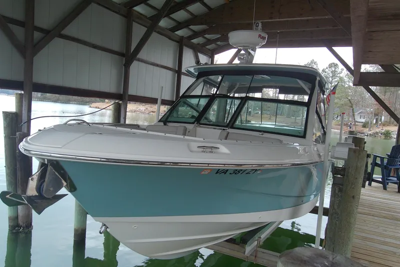 The Image of 2021 Boston Whaler 280 Vantage boat docked under a covered pier. - 1
