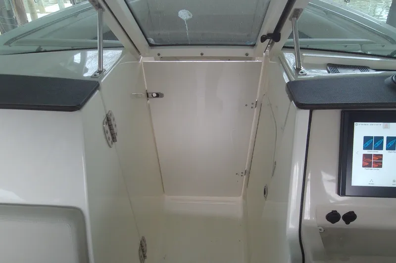 Slide: The Image of 2021 Boston Whaler 280 Vantage interior with control panel and cabin door. - 12