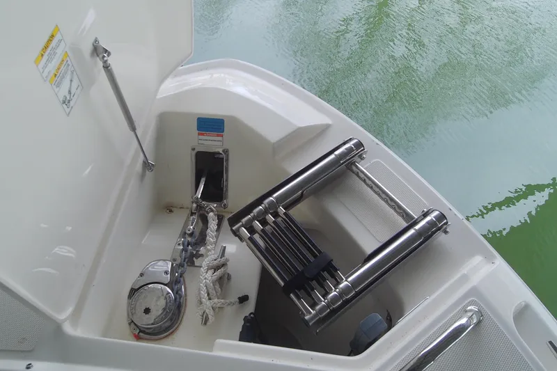 Slide: The Image of 2021 Boston Whaler 280 Vantage boat anchor compartment with ladder and ropes. - 16
